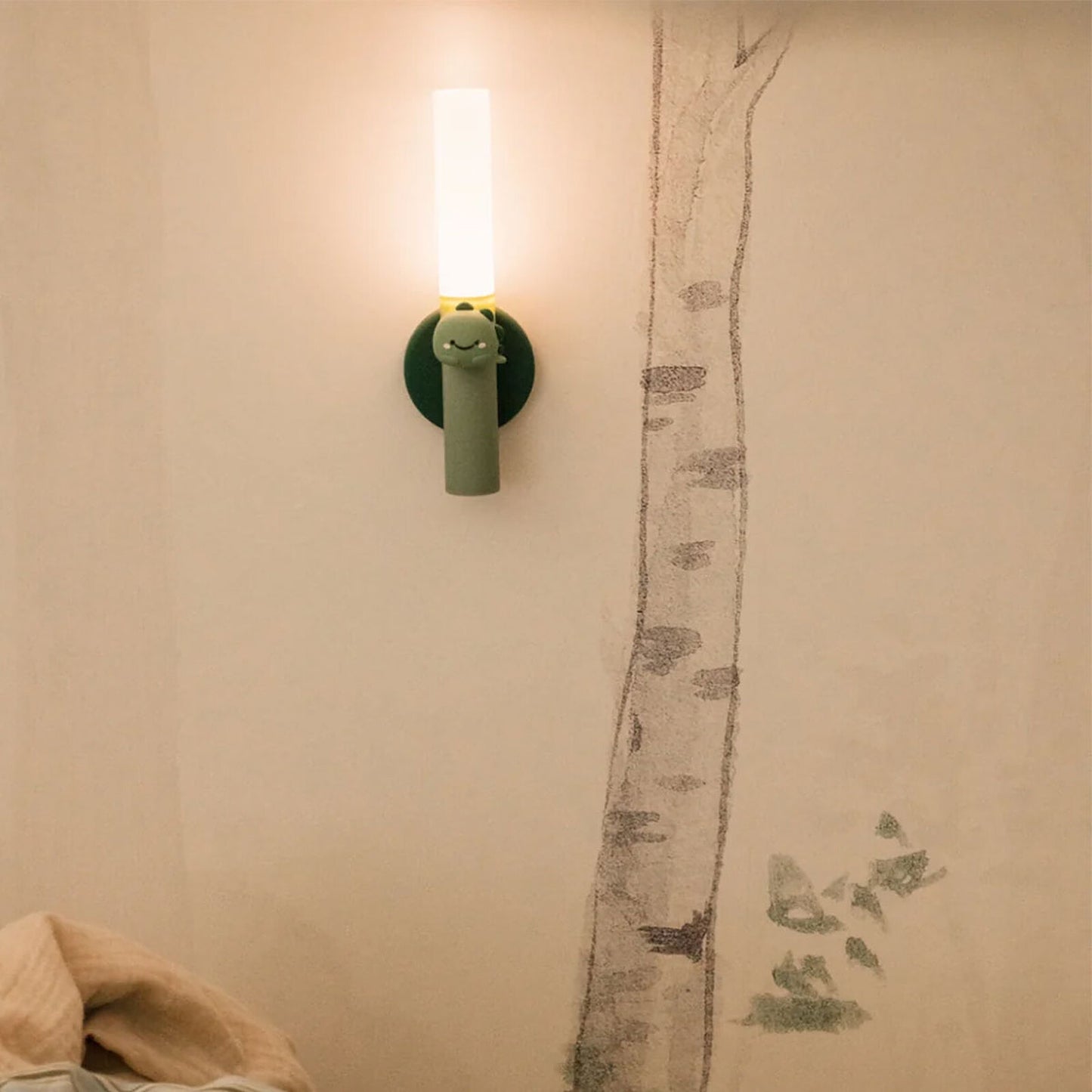 Lampe torche Dino Zoo Light fixée au mur en mode veilleuse de nuit