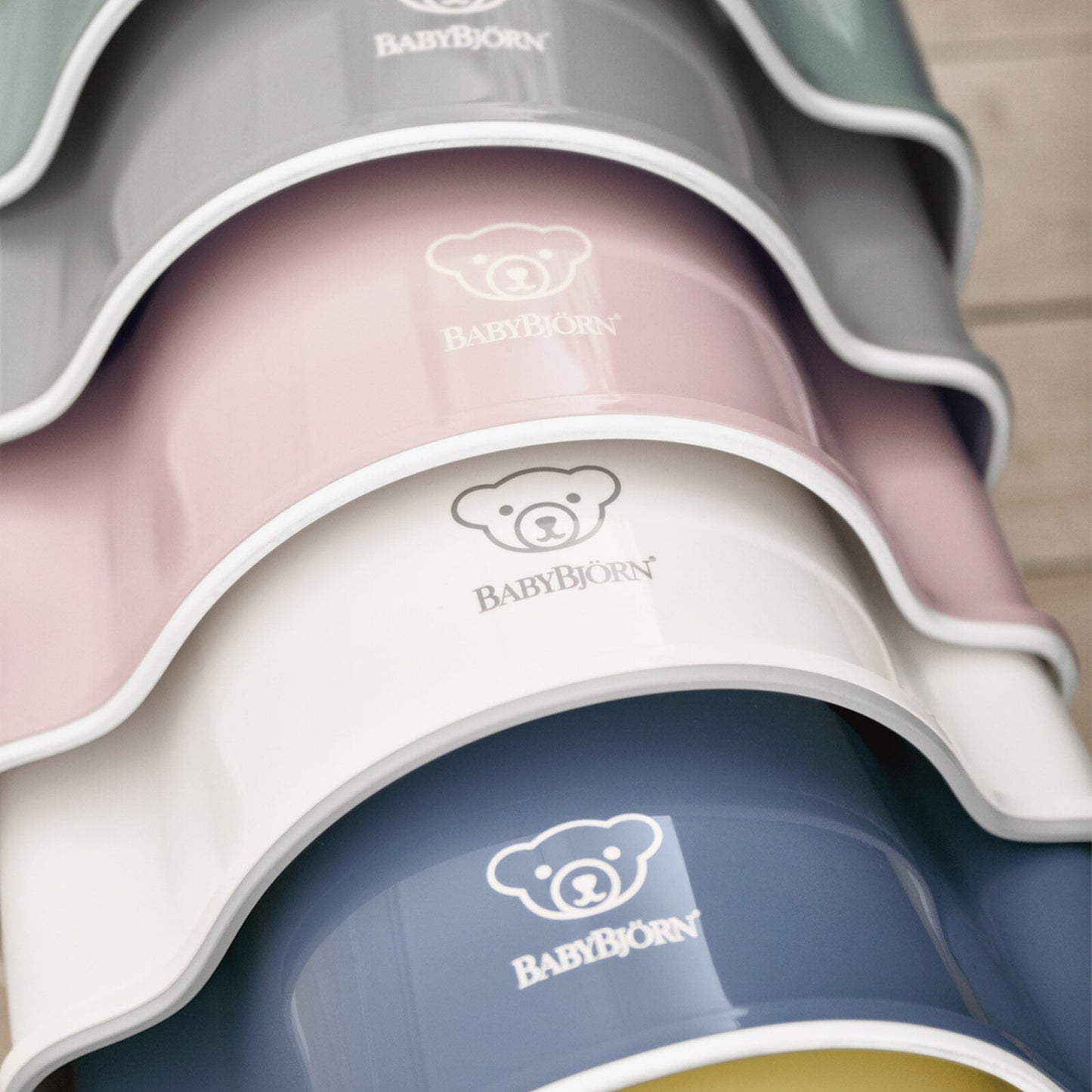 Vue rapprochée des pots pour bébé BabyBjörn Fastened en plusieurs couleurs – rose, blanc, bleu et gris