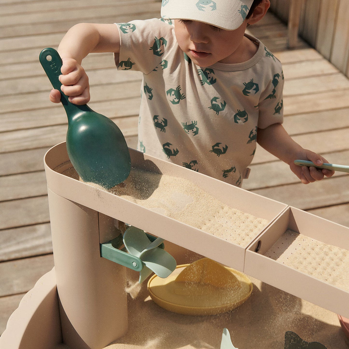 ALT : Enfant jouant à la table Sepp Liewood