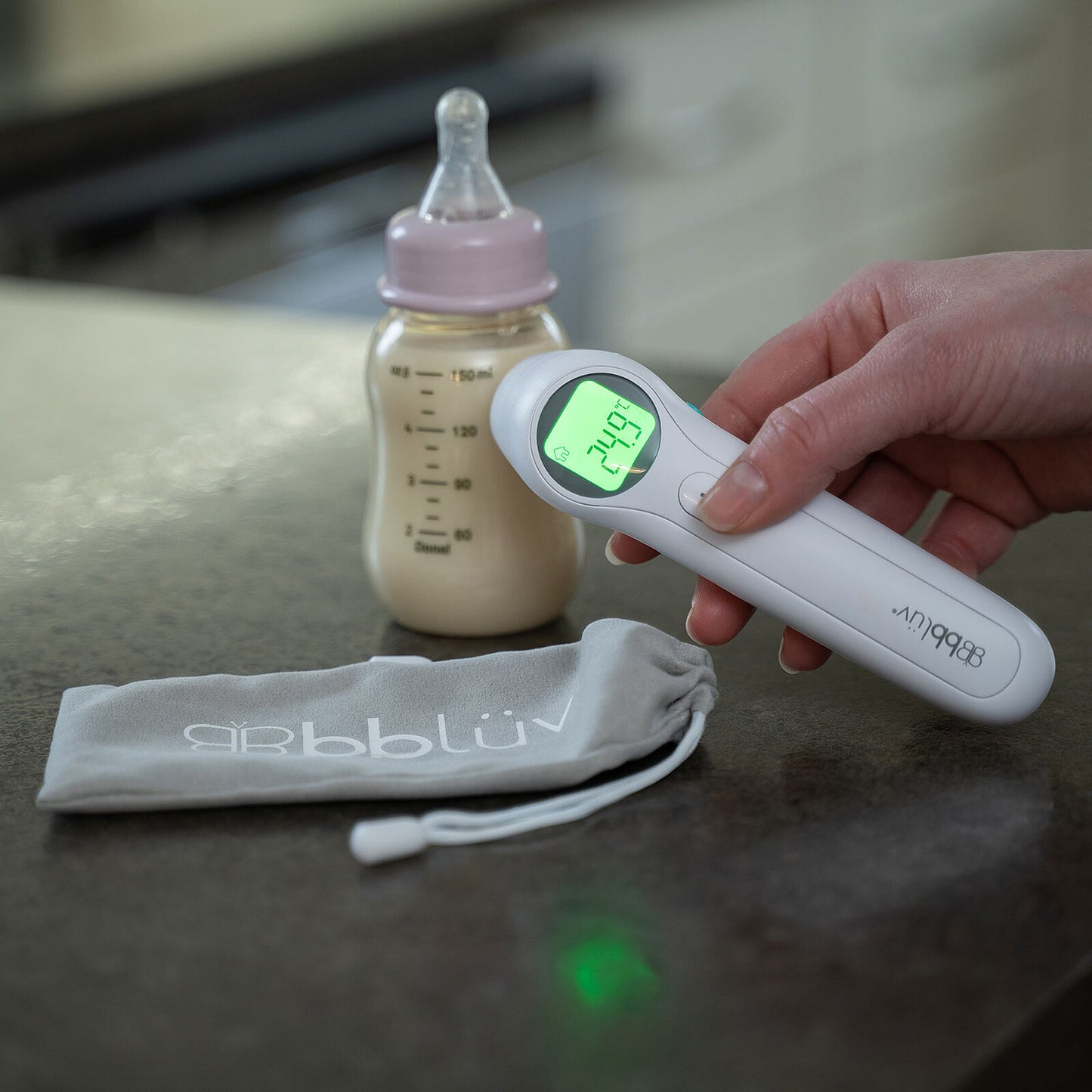 Thermomètre numérique Bblüv Orä 5-en-1 mesurant la température d’un biberon