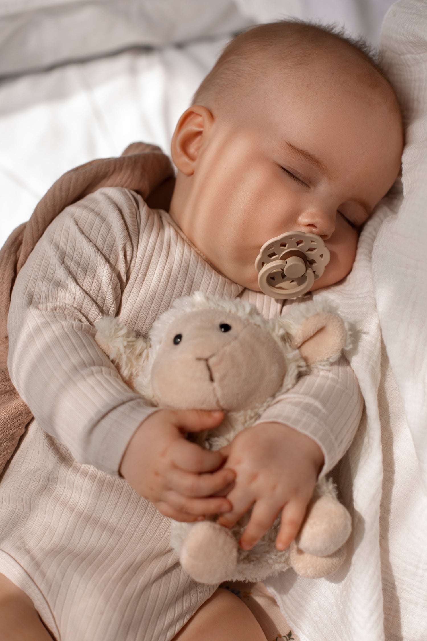 Bébé endormi paisiblement avec un doudou en peluche dans son lit