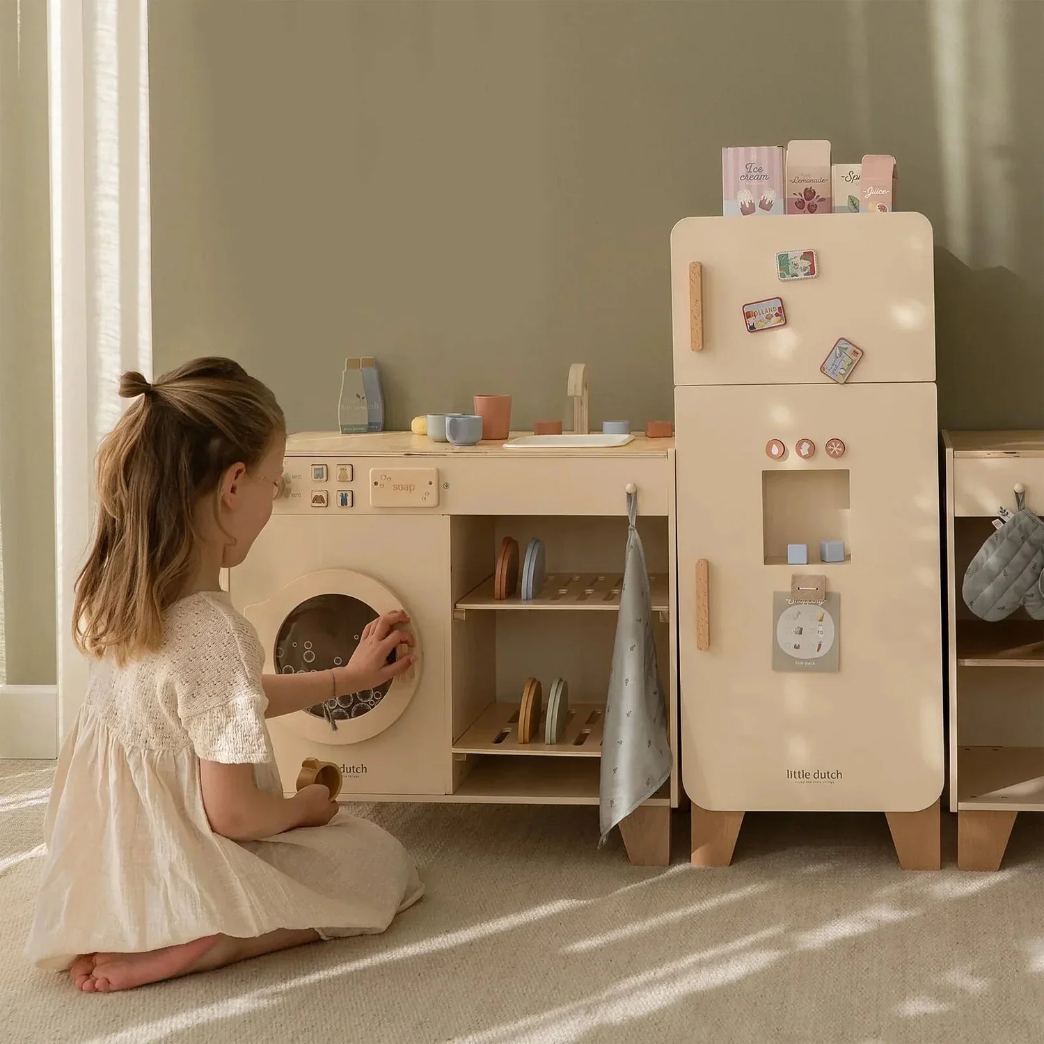 Blocs de lettres colorés formant le mot PLAY avec des jouets pour bébé en arrière-plan
