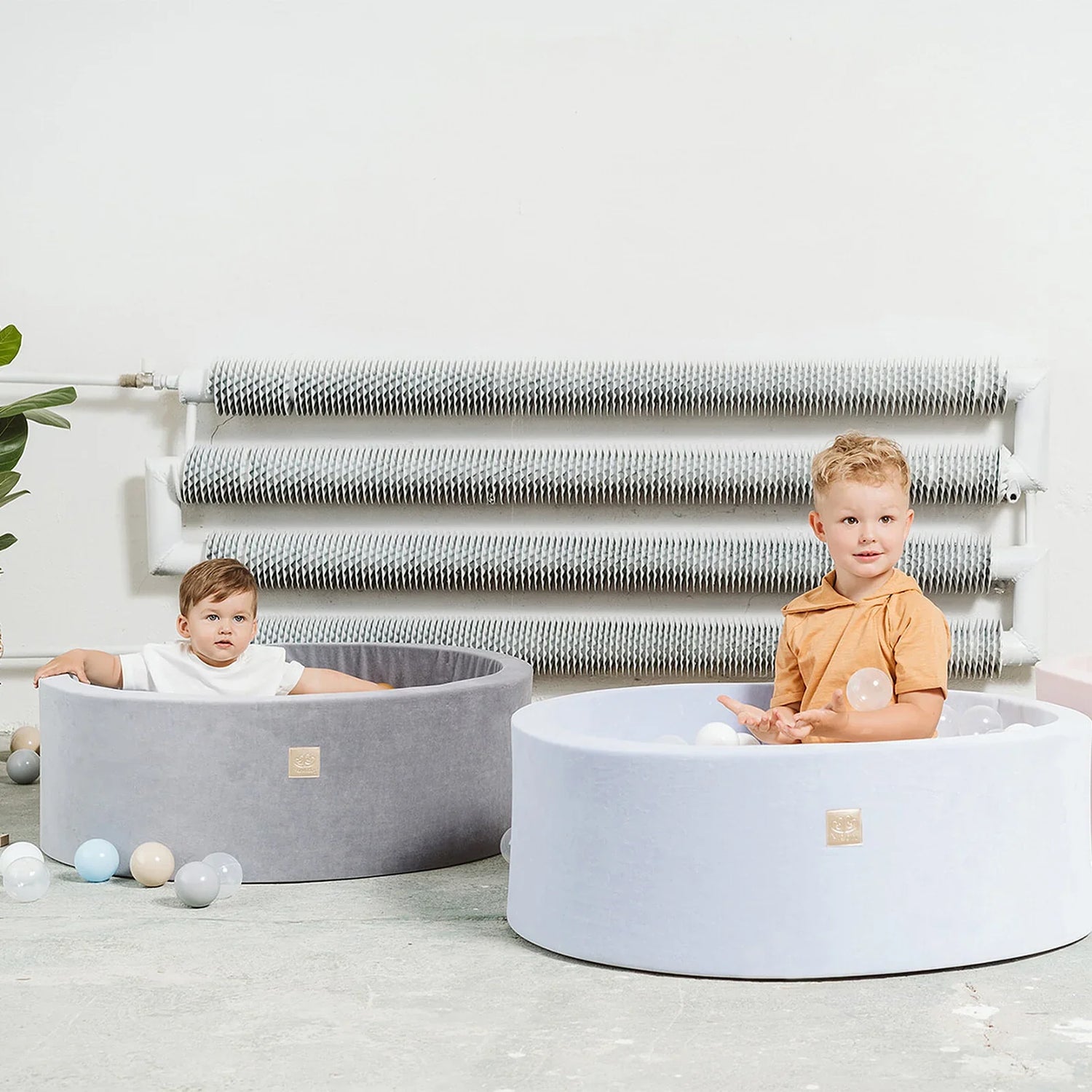 “Deux enfants jouent dans des piscines à balles grises – éveil, motricité et activités pour bébé.”