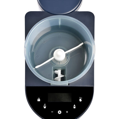 BÉABA Milkéo Plus Night Blue en utilisation sur plan de travail, préparation rapide d’un biberon.