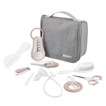 Trousse de toilette nomade Béaba coloris Old Pink posée sur une table de chambre bébé