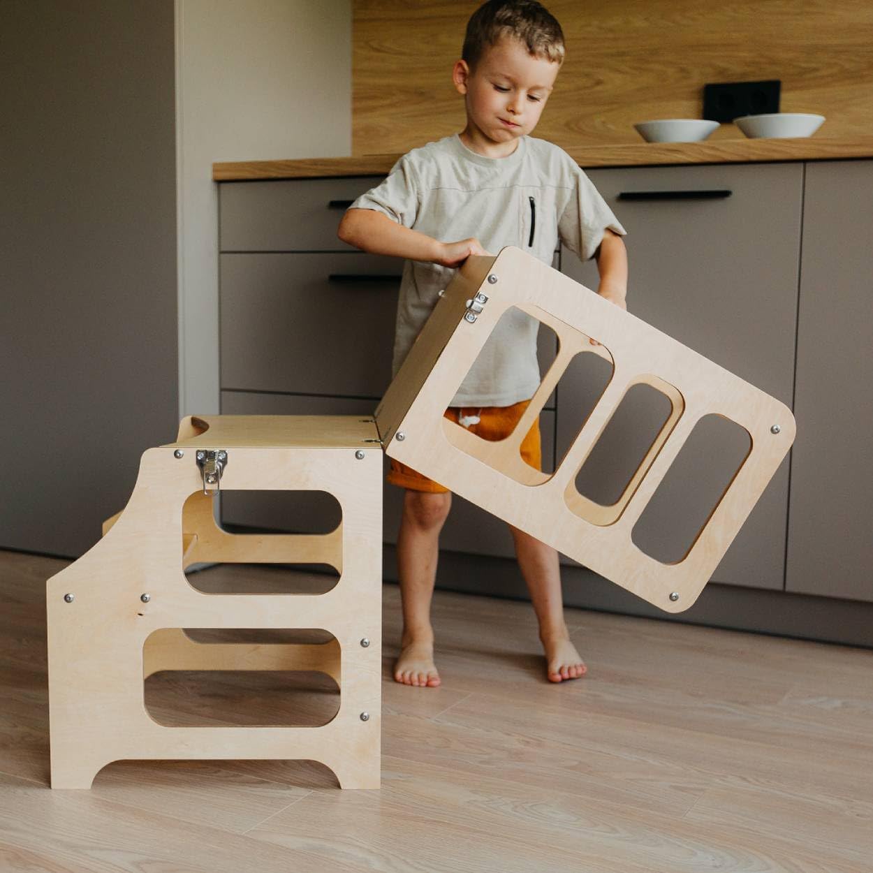 Enfant utilisant la tour de cuisine pliable Duck Woodworks
