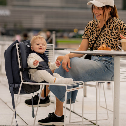 Parent portant le sac à dos MiniMeis HERO G5 Black en extérieur