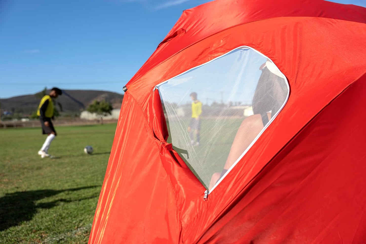 Fenêtre latérale du parasol SportBrella BRE01-050-02 – aération et visibilité depuis l’intérieur de l’abri de plage rouge.